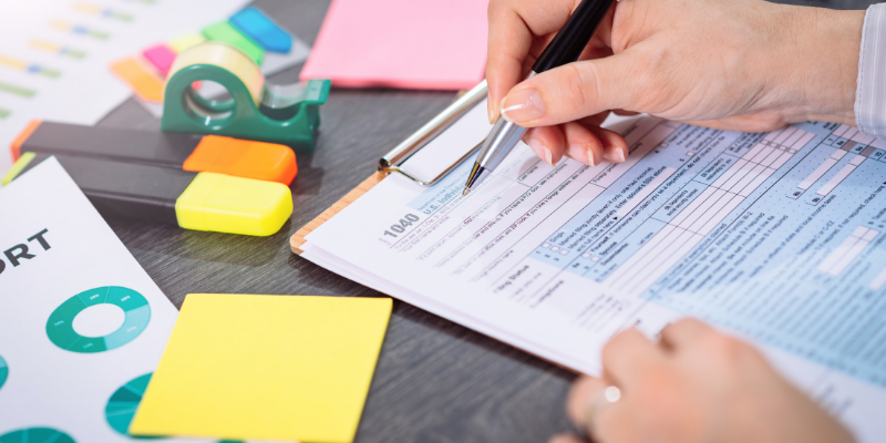 a person writing in  a piece of paper with pen