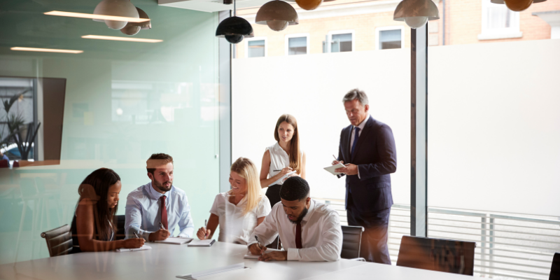 a group of people standing around the table