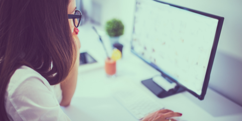 a woman sitting at a desk with a laptop 