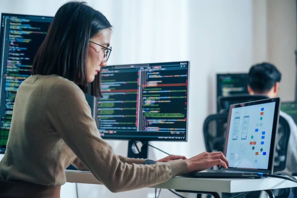 data analyst using her laptop and computers